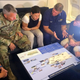 Duke, center, is briefed on the Hurricane Maria response during a flight to Puerto Rico in September.